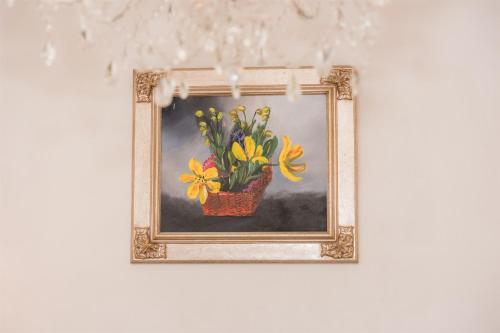 a painting of a vase of flowers on a wall at Kuća za odmor Dugo Selo M&A in Dugo Selo