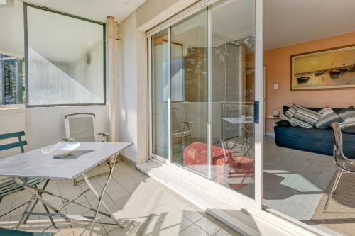 une pièce vitrée avec une table et un canapé dans l'établissement Studio Cosy Au Bord De L'eau, au Pouliguen