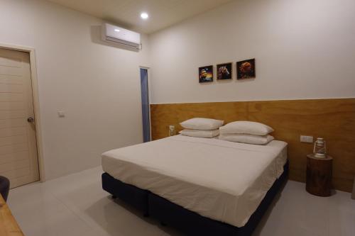 a bedroom with a bed with white sheets and pillows at Stay Kora in Thinadhoo
