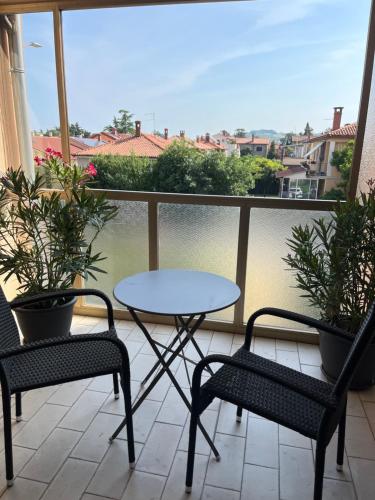 a table and two chairs on a balcony with plants at Apartment 7 in Izola