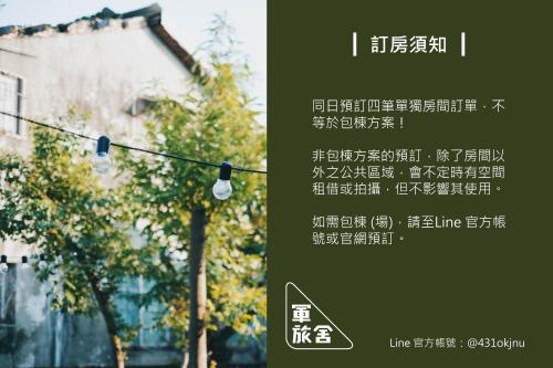 a sign with a street light in front of a building at Goonnight Hostel in Kaohsiung