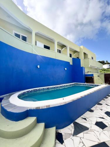 a blue and white building with a swimming pool at Cozy Retreat With Stunning View in Philipsburg