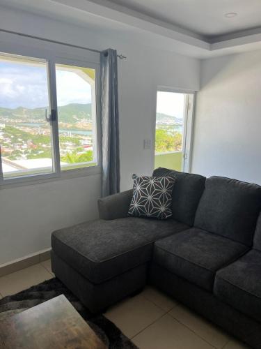 a living room with a couch and two windows at Cozy Retreat With Stunning View in Philipsburg