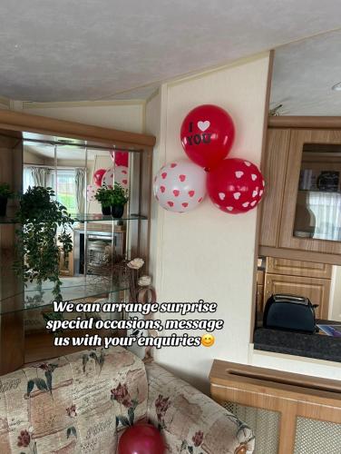 a room with red and white balloons on the wall at West Lakes Affordable Caravan in Lamplugh