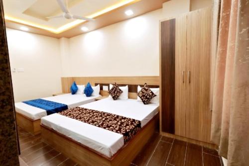 two beds in a room with wooden floors at Hotel Royal Suites In Ajmer in Ajmer