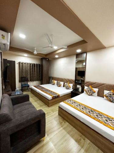 a hotel room with two beds and a couch at Hotel Royal Suites In Ajmer in Ajmer