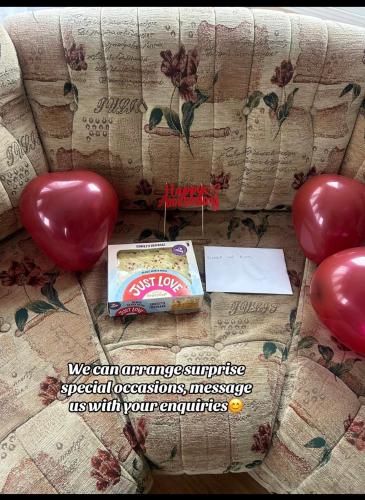 a couch with red balloons and a box of chips at West Lakes Affordable Caravan in Lamplugh