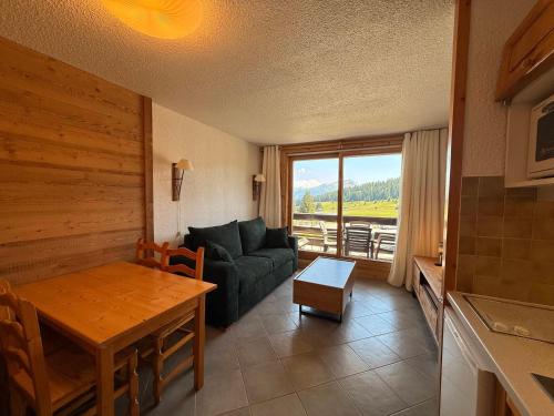un salon avec un canapé et une table dans l'établissement Les Saisies - Studio Cabine avec Garage pour 4-5 personnes, ensoleillé, vue sur pistes, non fumeur - FR-1-293-152, aux Saisies