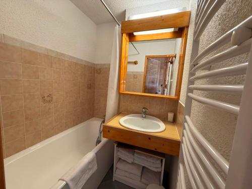 une salle de bain avec un lavabo, un miroir et une baignoire dans l'établissement Les Saisies - Studio Cabine avec Garage pour 4-5 personnes, ensoleillé, vue sur pistes, non fumeur - FR-1-293-152, aux Saisies