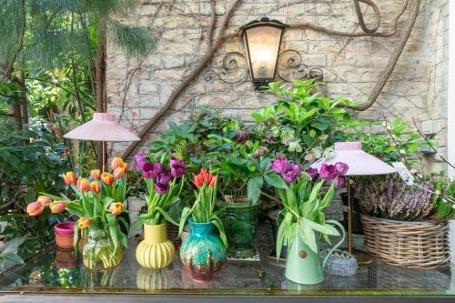 a group of vases with flowers on a table at Hotel Schwalbe in Vienna