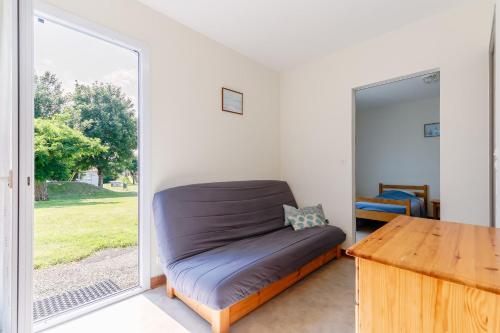 un lit dans une chambre avec une grande fenêtre dans l'établissement 09 - Le Héron - Village vacances, à Maché