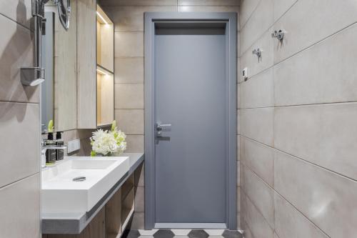 a bathroom with a white sink and a mirror at Eurostars Metropole in Rīga