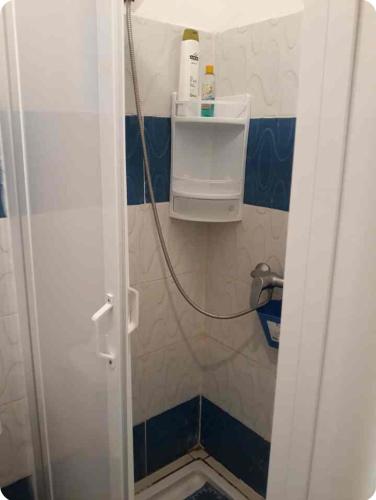 a small bathroom with a shower with a hose at Beau appartement à saidia in Saïdia