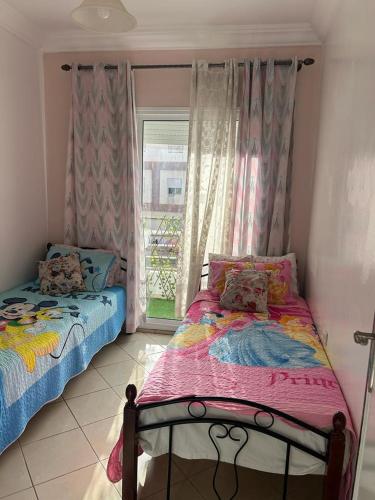 a bedroom with two twin beds and a window at Beau appartement à saidia in Saïdia