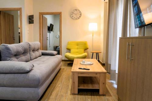 Ruby's Apartments Platamonas في بلاتامون: غرفة معيشة مع أريكة وطاولة