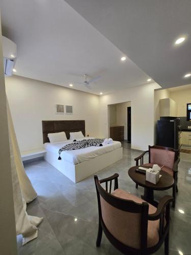 a bedroom with a bed and a table and chairs at Lavish Apartments with Pool Candolim Luxfort in Candolim