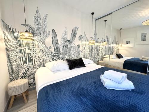 une chambre avec un lit bleu et une fresque murale de plantes dans l'établissement ApartHotel Riviera - Terrasse Loft de la Providence - Vieille Ville - Esprit Loft en 2 pices AC, à Nice