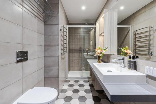 a bathroom with two sinks and a shower and a toilet at Eurostars Metropole in Rīga