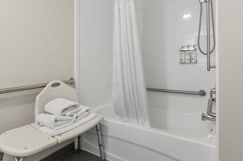 a white bathroom with a chair and a bath tub at Holiday Inn Express Princeton/I-77 by IHG in Princeton