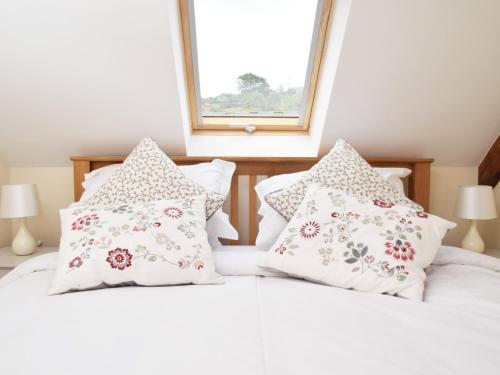 Un dormitorio con dos camas con almohadas y una ventana. en 4 Bed in Berrynarbor 43640, en Berrynarbor