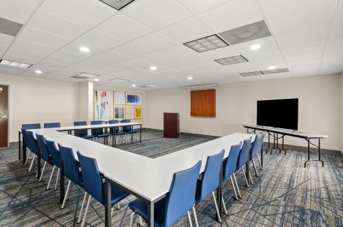 a conference room with a table and chairs and a screen at Holiday Inn Express Princeton/I-77 by IHG in Princeton