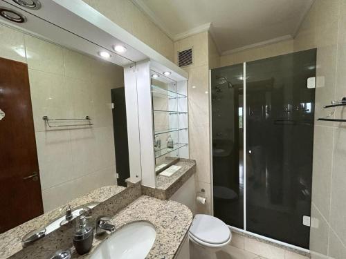 a bathroom with a toilet and a sink and a shower at Gramado Village Apartamento no Centro in Gramado