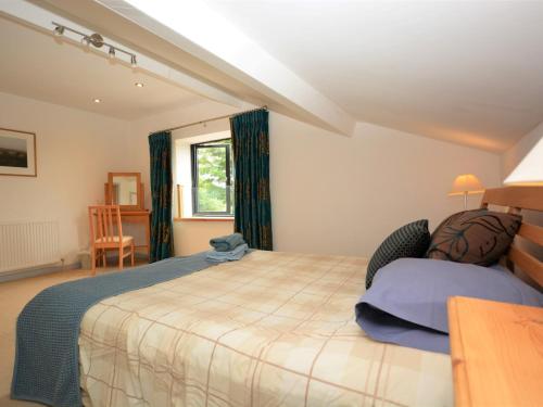 a bedroom with a large bed and a window at 3 Bed in Blandford Forum 49993 in Milton Abbas