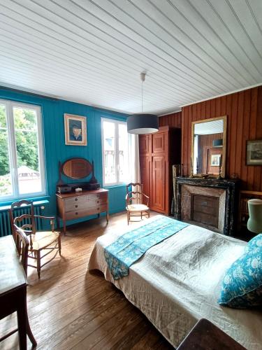 1 dormitorio con 1 cama grande en una habitación con paredes azules en Le Cinquante-Trois, en Saint-Valéry-en-Caux
