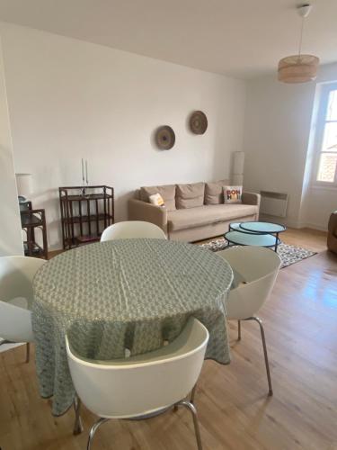 un salon avec une table et des chaises dans l'établissement Appartement cosy dans la bastide, à Sainte-Foy-la-Grande