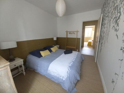 une chambre avec un lit avec des oreillers bleus et jaunes dans l'établissement La Tour Bleue, à Chânes