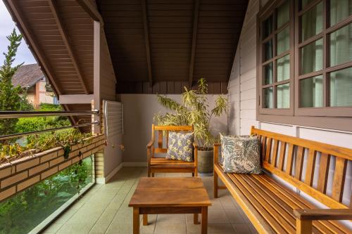 a porch with two benches and a table at Resort Ecoar in Gaspar