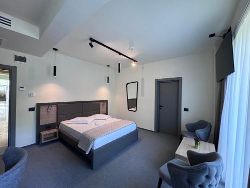 a bedroom with a bed and two blue chairs at Hotel Eforie Nord in Eforie Nord