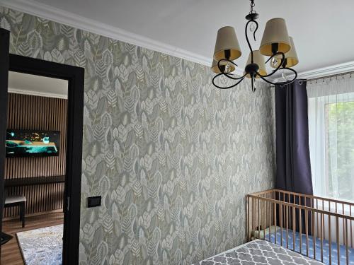 a bedroom with a crib and a wall with a pattern at Elen White Apartment in Rēzekne