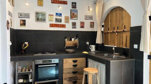 a kitchen with a counter with a sink and a stove at VILLA "MYKONOS" pour vos moments de détente en famille piscine privative, 3 chambre climatisées, salon climatise télé machine a laver cuisine, jardin arbore gardien parking 100 m de la plage in Ngaparou