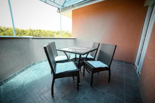 a table and chairs on a balcony with a window at Garni Hotel Radović in Kragujevac