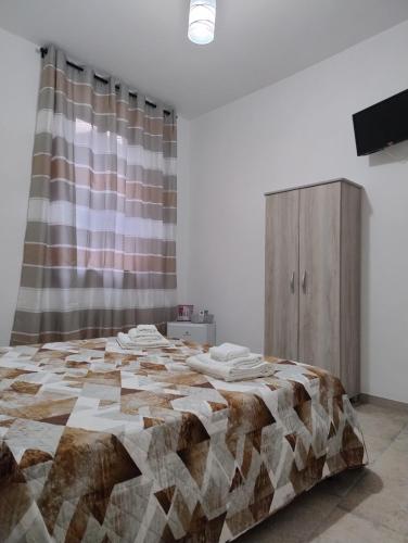 1 dormitorio con 1 cama grande frente a una cortina en La Casa Di Nonna Lucrezia, en Orsomarso