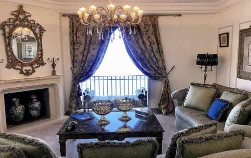 a living room with a couch and a chandelier at Majestic Monaco Villa in La Turbie