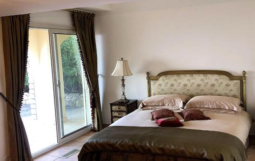 a bedroom with a bed with pillows and a window at Majestic Monaco Villa in La Turbie