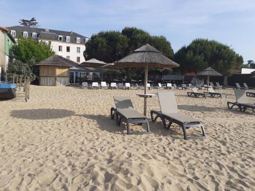 una playa con sillas y una sombrilla en la arena en Serenity Housse, en La Tremblade