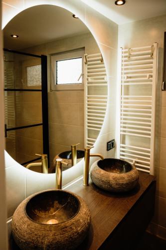 two sinks in a bathroom with a large mirror at Veluwse Wellness Lodge Selina in Ermelo