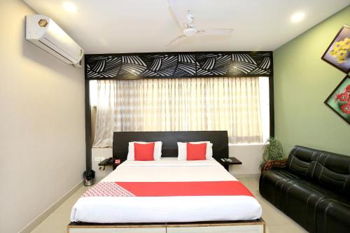 a bedroom with a large bed and a couch at Super Hotel O Karma in Jalandhar
