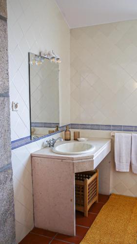 a bathroom with a sink and a mirror at Quinta da Chanca in Paredes de Coura