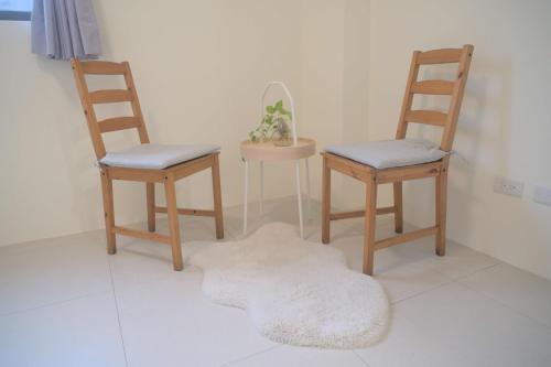 a room with three chairs and a rug on the floor at Yuejin Port B&B in T'u-k'u