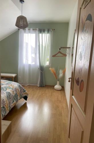 a bedroom with a bed and a window at paddock pétillant in Auménancourt-le-Grand