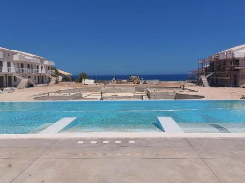 a swimming pool with the ocean in the background at Acquamarina in Pachino