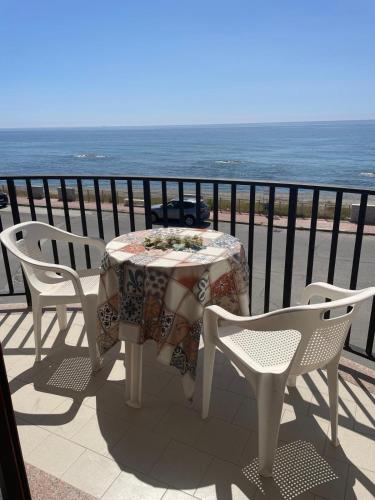a table and chairs on a balcony with the ocean at Hotel Lungomare Brancaleone in Brancaleone Marina