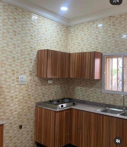 a kitchen with wooden cabinets and a stove in it at Jackson's Court and Apartment in Abuja