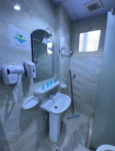 a bathroom with a sink and a toilet and a mirror at AL-Diyafh Hotel in Az Zāhir