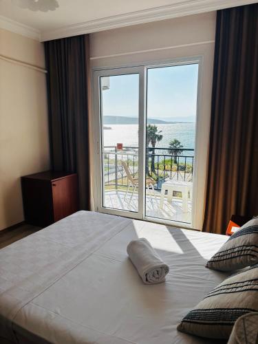a bedroom with a bed with a view of the ocean at Albayrak Hotel in Çeşme