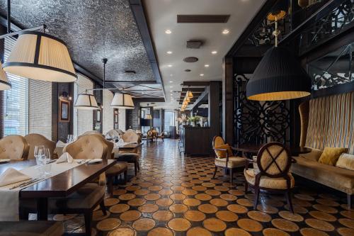 a dining room with tables and chairs and lights at Eurostars Metropole in Rīga